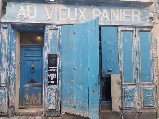 Weathered blue facade of Au Vieux Panier shop in Le Panier, Marseille, highlight of the oldest neighborhood walking tour