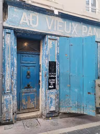 Weathered blue “Au Vieux Panier” facade in the old district, a photostop on the street art and craft tour