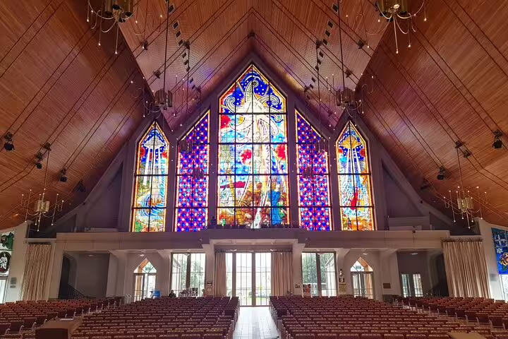 Interior view of Auckland church featuring vibrant stained glass windows during city highlights tour.