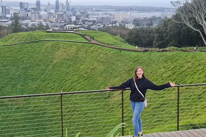 Visitor enjoying the stunning view of Auckland cityscape from Mount Eden on a half-day highlights tour.