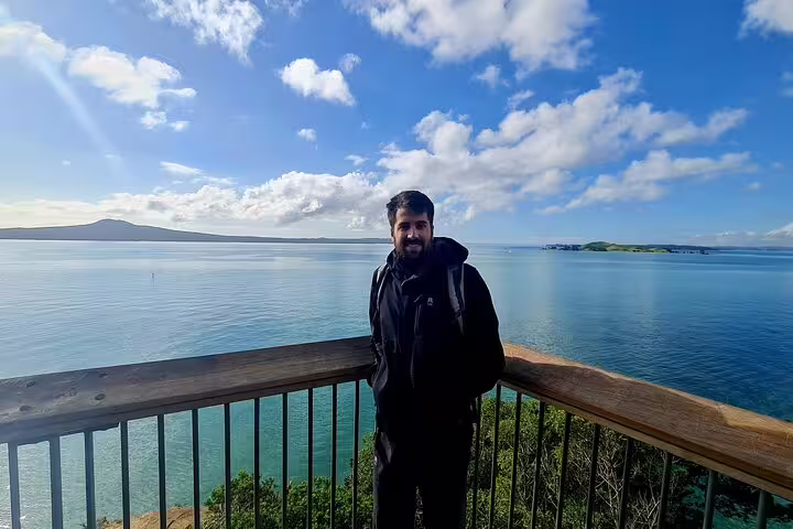 Visitor enjoying stunning ocean views from a scenic lookout on the Private Auckland Highlight Day Tour.