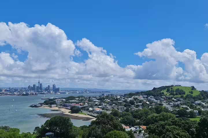 Stunning view of Auckland's skyline and Rangitoto Island under a bright blue sky from a high vantage point.