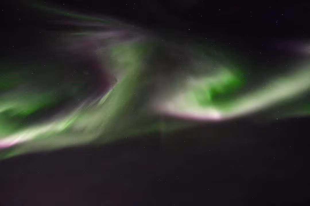 Vivid green aurora borealis swirling across a starry sky, ideal for northern lights and stargazing tour