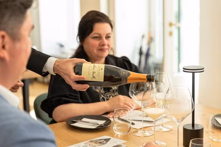 Pouring Austrian sparkling wine into tasting glasses during a Vienna wine tasting experience with expert guidance
