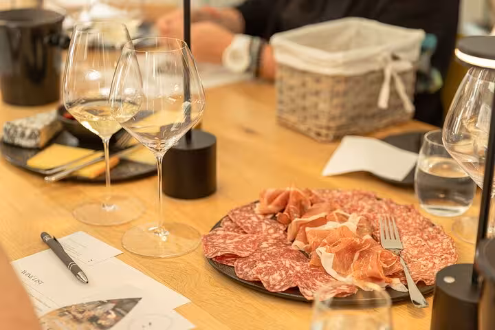 Charcuterie plate with cured meats and wine glasses at an Austrian wine tasting experience in Vienna