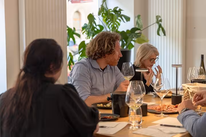 Guests swirl and sip Austrian wines with cheese pairings during a guided Vienna wine tasting experience