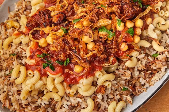 Savor authentic Egyptian koshari with pasta, rice, lentils, and crispy onions on the Cairo food tour.