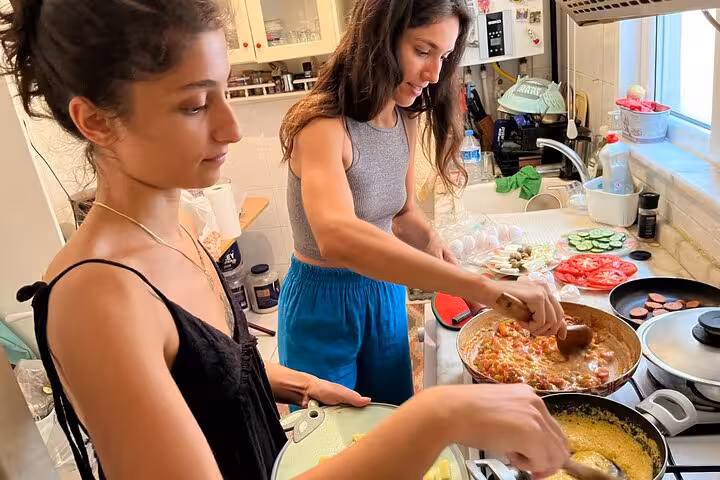 Guests cook menemen together in a home kitchen, preparing an authentic Turkish breakfast with local friends