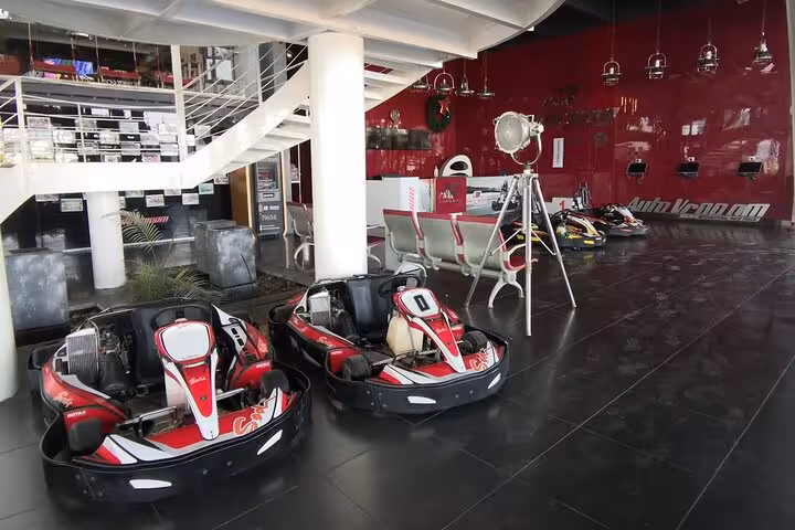 AUTOVROOOM karting lounge with red-and-black go-karts lined up, modern seating and indoor facility