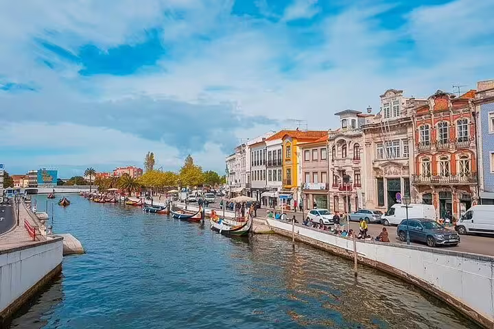Charming canal in Aveiro with colorful boats and historic architecture, highlighted in a private tour from Porto.