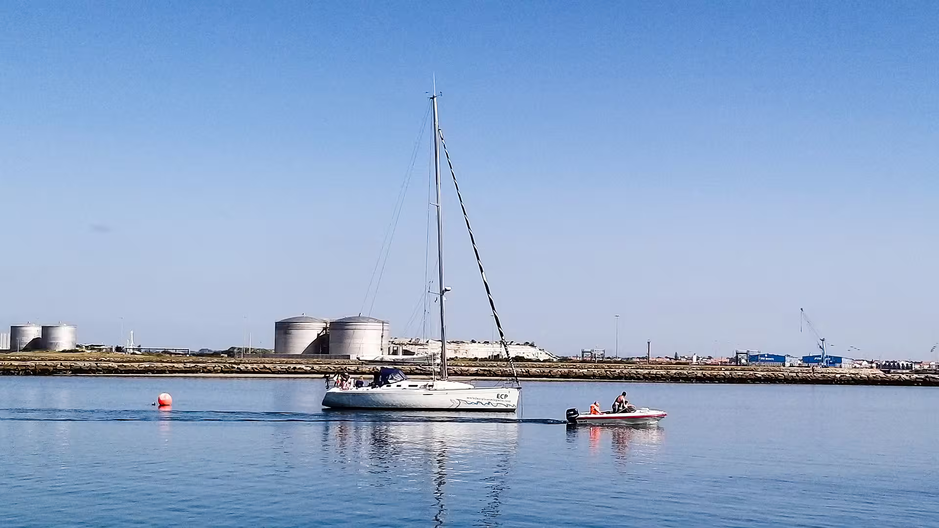 Sailboat and motorboat on calm waters near Aveiro, highlighting the serene coastal beauty of a private tour to Costa Nova.