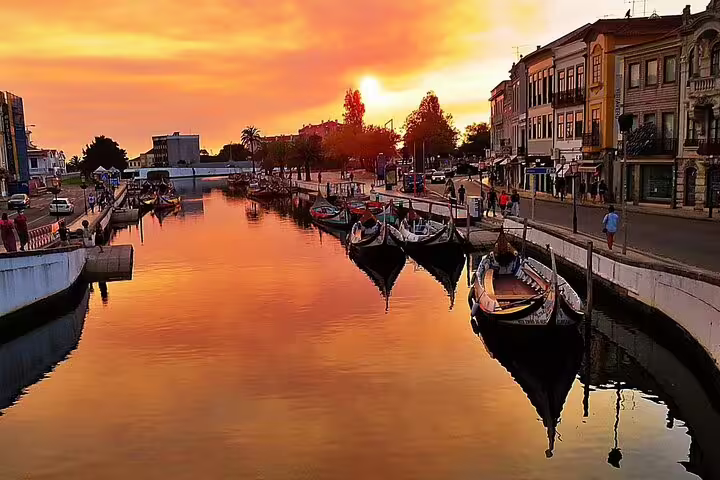 Sunset over Aveiro's canal with traditional boats and historic buildings, featured in the private tour from Porto.
