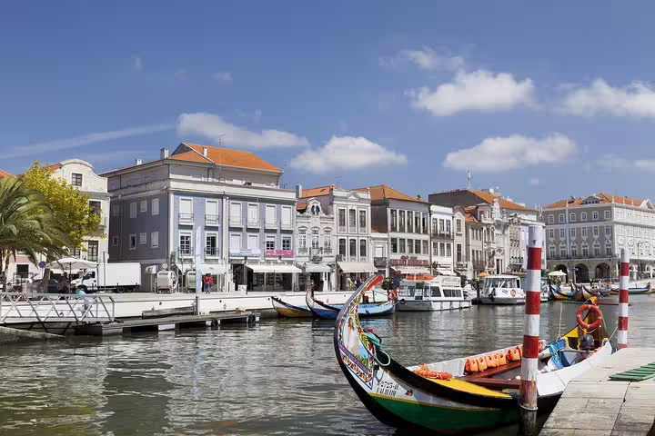 Colorful moliceiro boat docked along Aveiro's canal with charming historic buildings in the background.