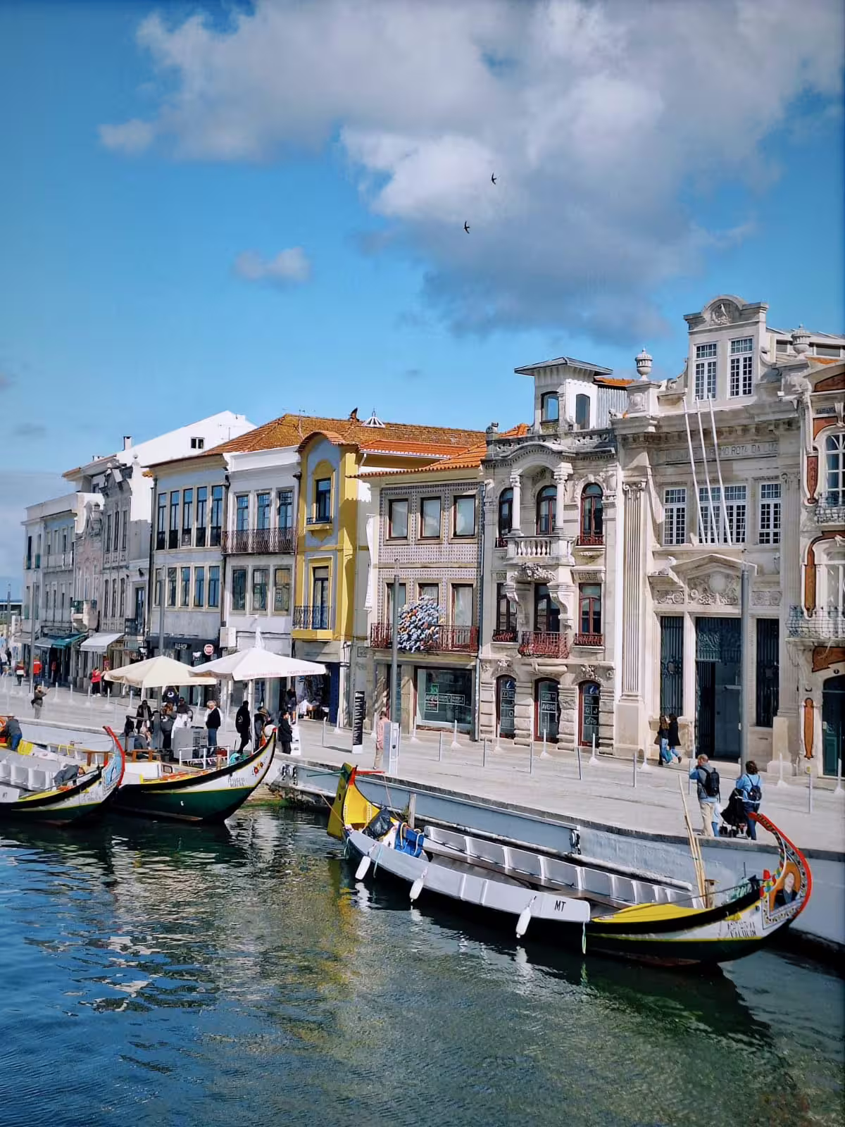 Charming canal view of traditional moliceiro boats and historic buildings in Aveiro's picturesque city center.