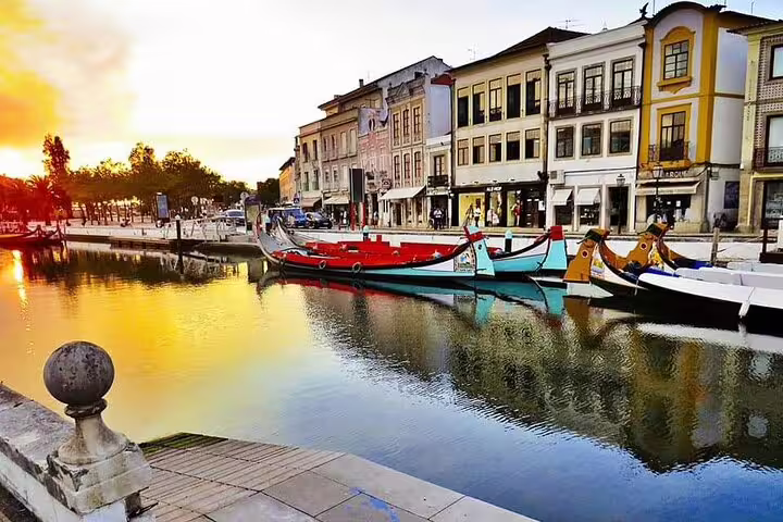 Scenic view of colorful moliceiro boats on Aveiro's canals at sunset during a private full-day tour from Porto.