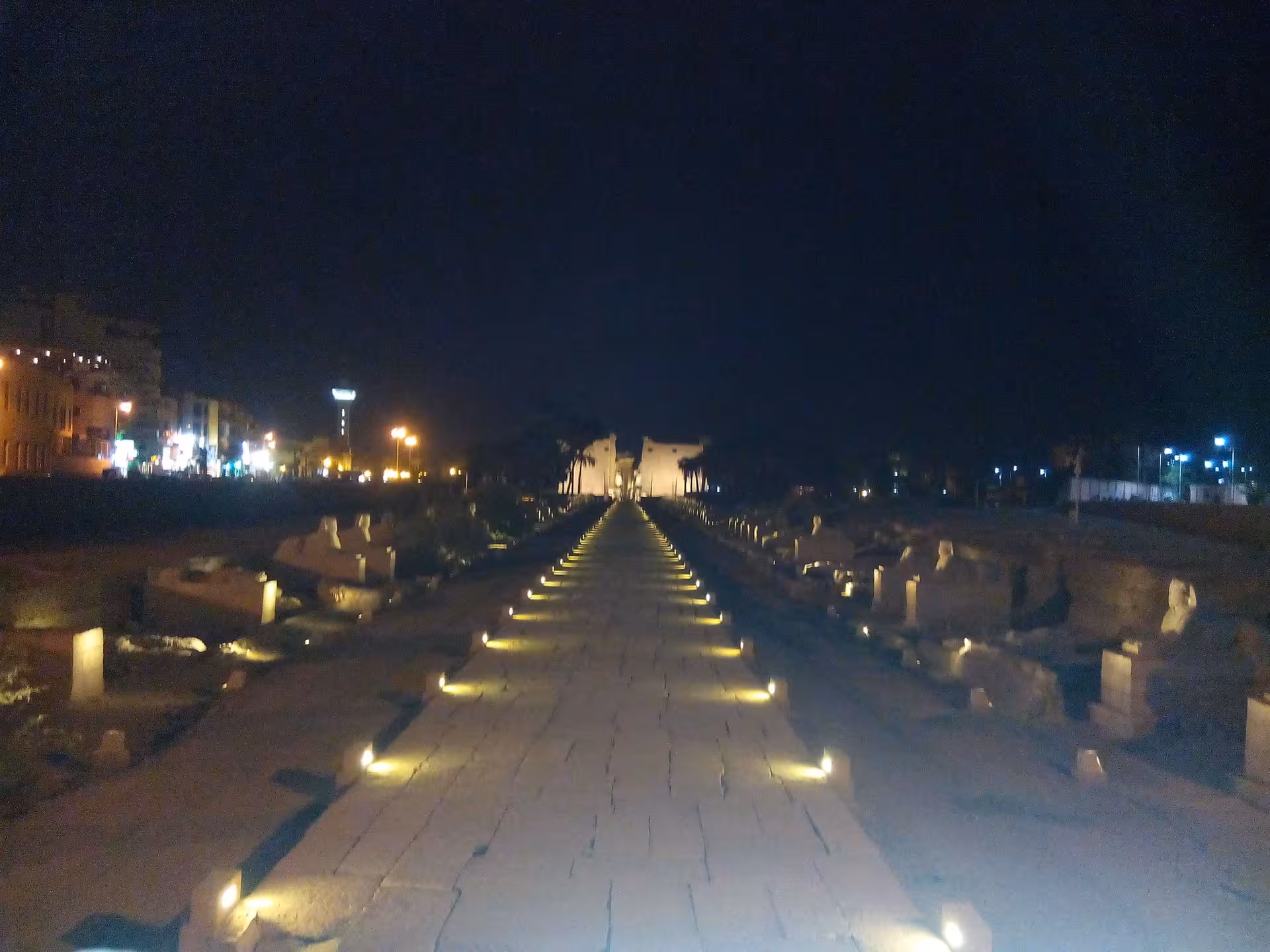 Illuminated Avenue of Sphinxes in Luxor at night, showcasing ancient Egyptian architecture and cultural heritage.