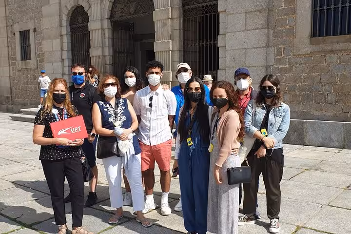 Travelers at historic site in Avila, enjoying a guided tour with masks for safety and cultural exploration.