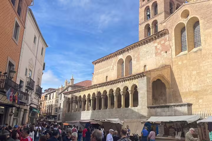 Bustling Avila old town market beside Romanesque church on private minivan day tour from Madrid