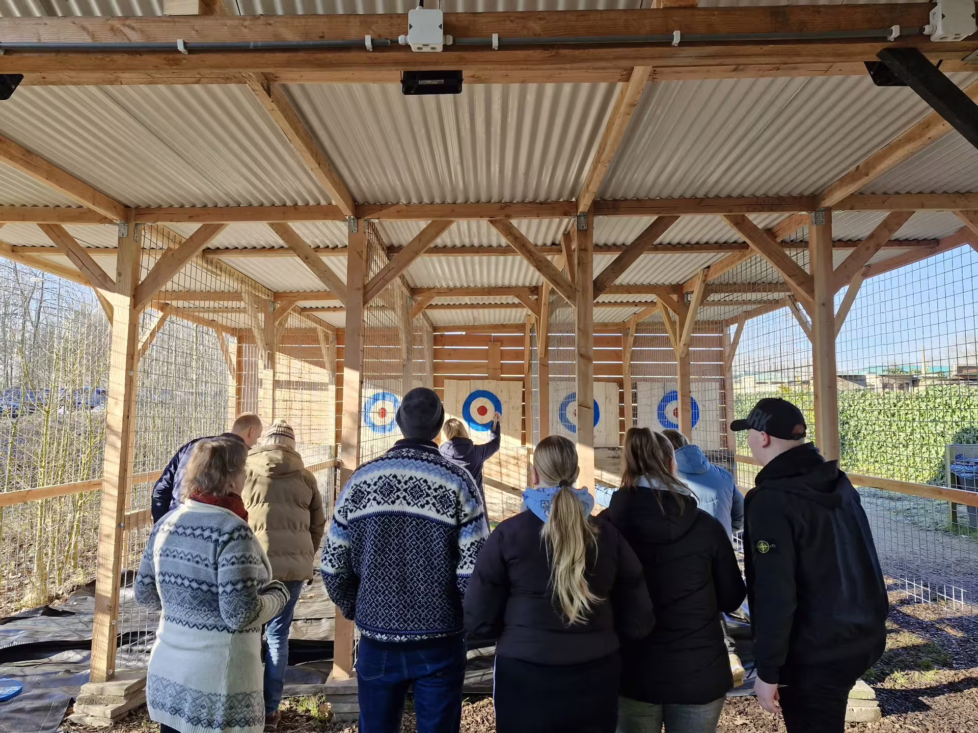 Group watching an axe throwing session in Amsterdam, indoor lanes with targets, guided team activity experience