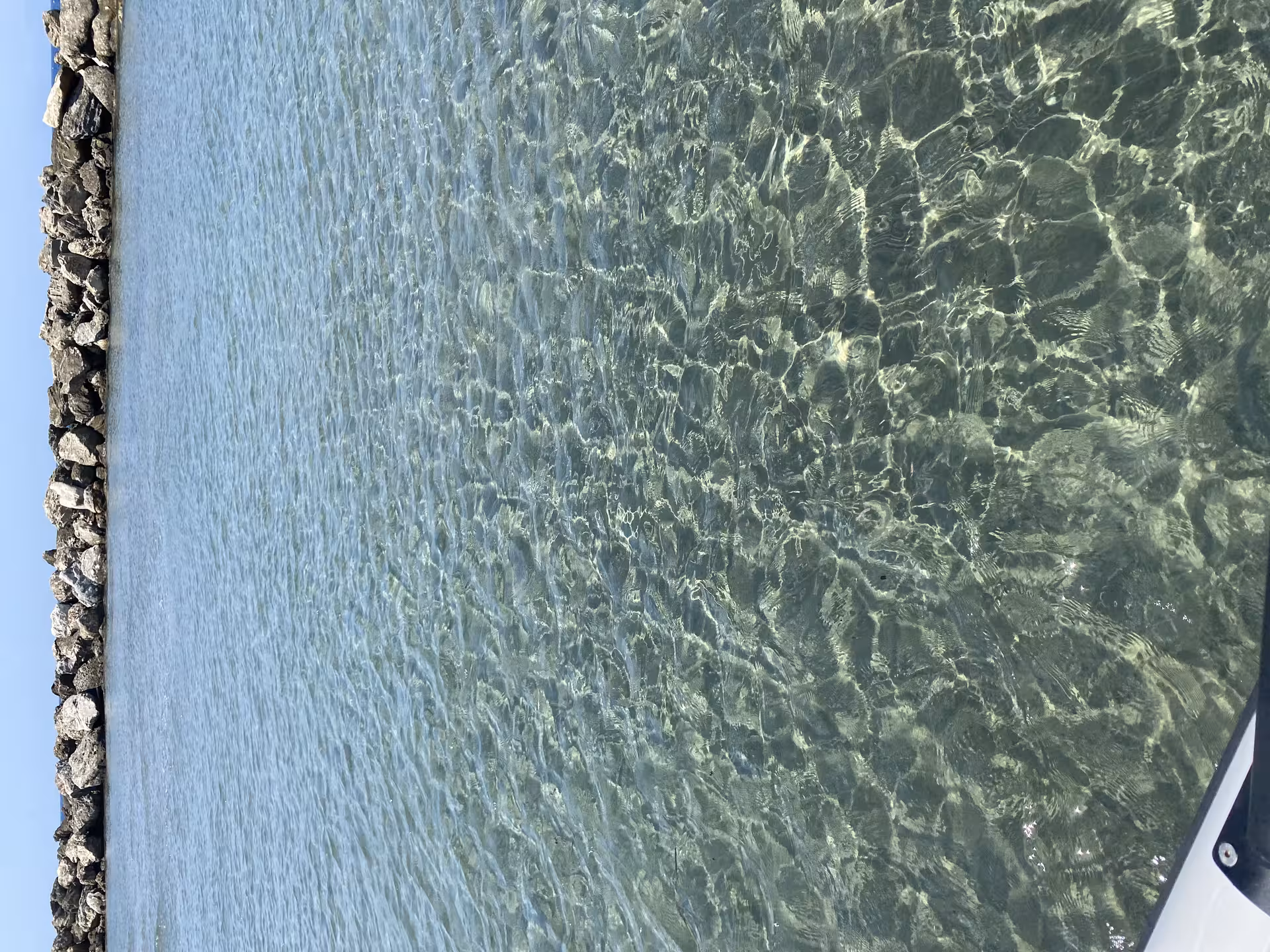 Crystal-clear shallow lagoon water by rocky islets on Discover Emerald Islets Axopar 25 CT boat tour