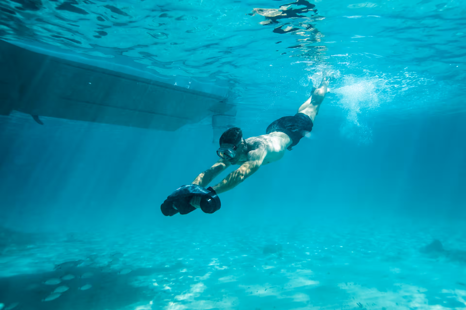 Snorkeler gliding in crystal-clear turquoise water beside the Axopar 25 CT on the Discover Emerald Islets tour