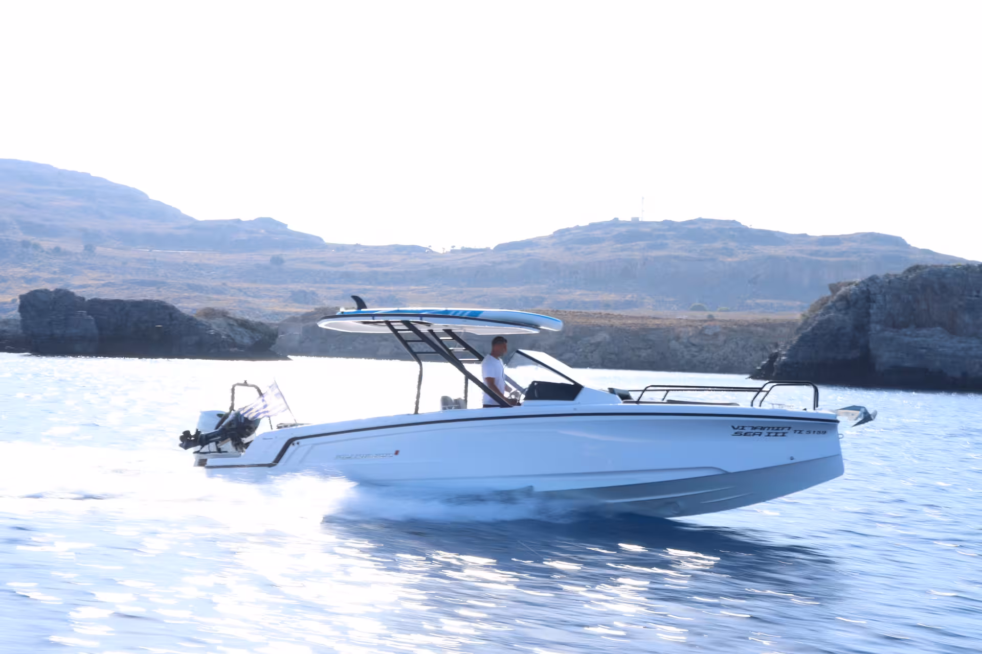 Axopar 25 CT speedboat cruising past rugged emerald islets on a scenic island-hopping tour in clear blue water