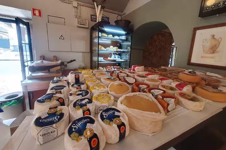 Local cheese selection in Azeitão shop, showcasing diverse artisanal varieties for Arrábida tour visitors.