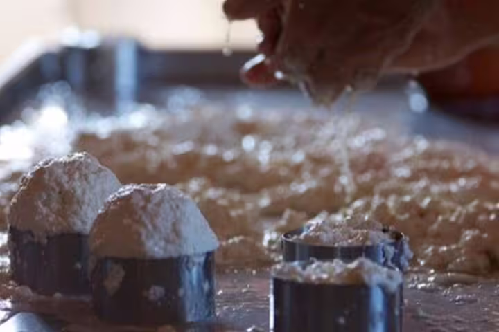 Hands crafting Azeitão cheese during a workshop, showcasing fresh curds and molds, part of a wine tasting and Sesimbra tour.