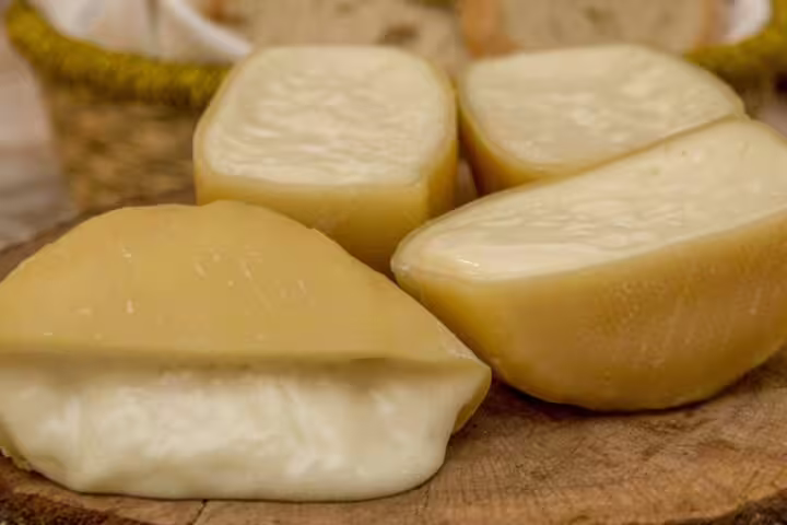 Azeitão cheese wedges on a wooden board, showcasing creamy texture, perfect for a cheese workshop and wine tasting tour in Sesimbra.