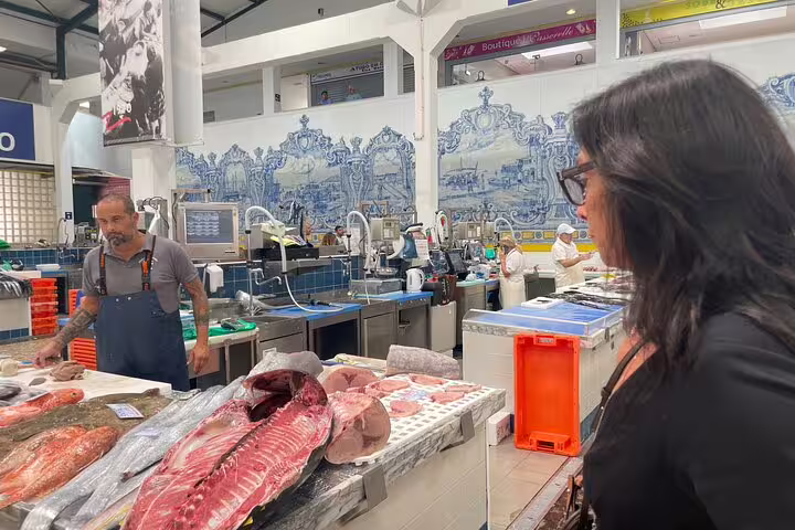 Customer exploring fresh seafood at a vibrant market during the Private Azeitão Cheese Workshop, Wine Tasting & Sesimbra Tour.