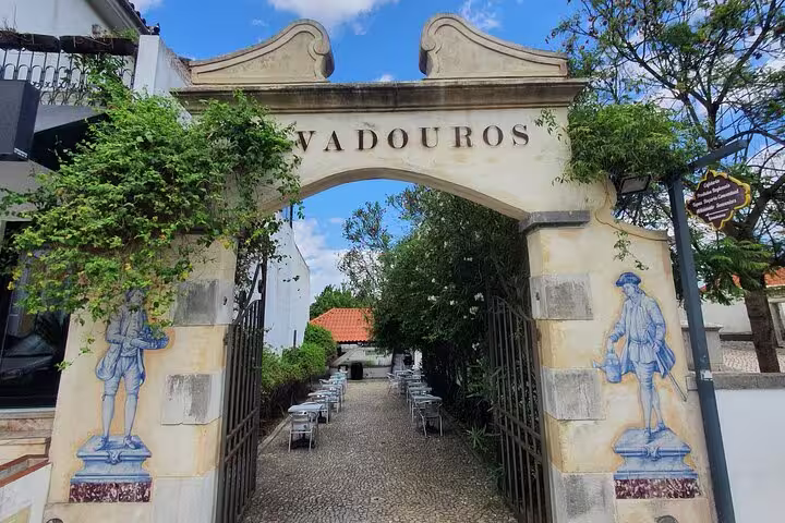 Historic entrance with traditional Portuguese tiles in Azeitão, showcasing a charming pathway on the Arrábida tour from Lisbon.
