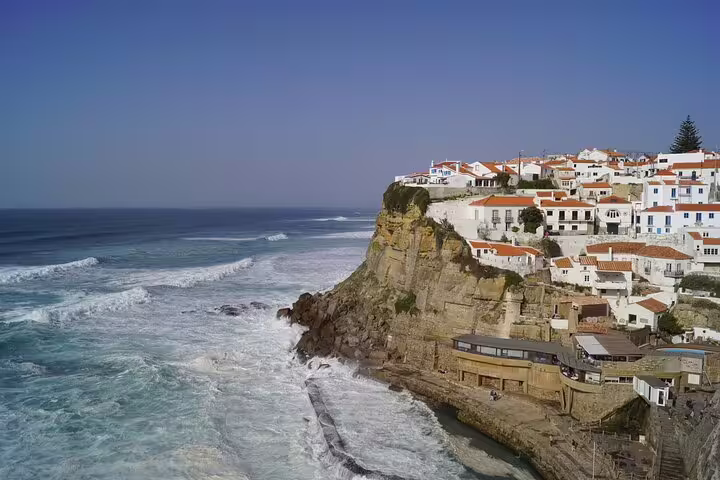 Scenic view of Azenhas do Mar, a picturesque coastal village with whitewashed houses perched on cliffs above the Atlantic Ocean.