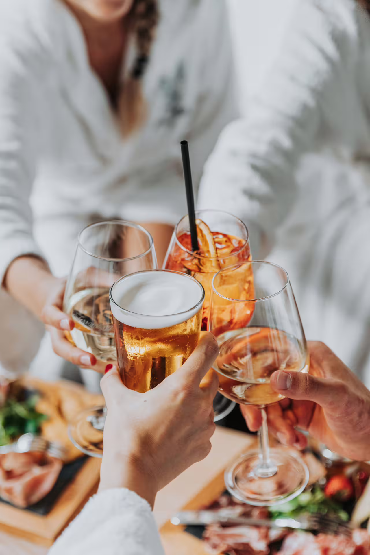 Guests clinking drinks during aperitif at Bagno di Romagna spa, paired with 25 min massage and thermal pools