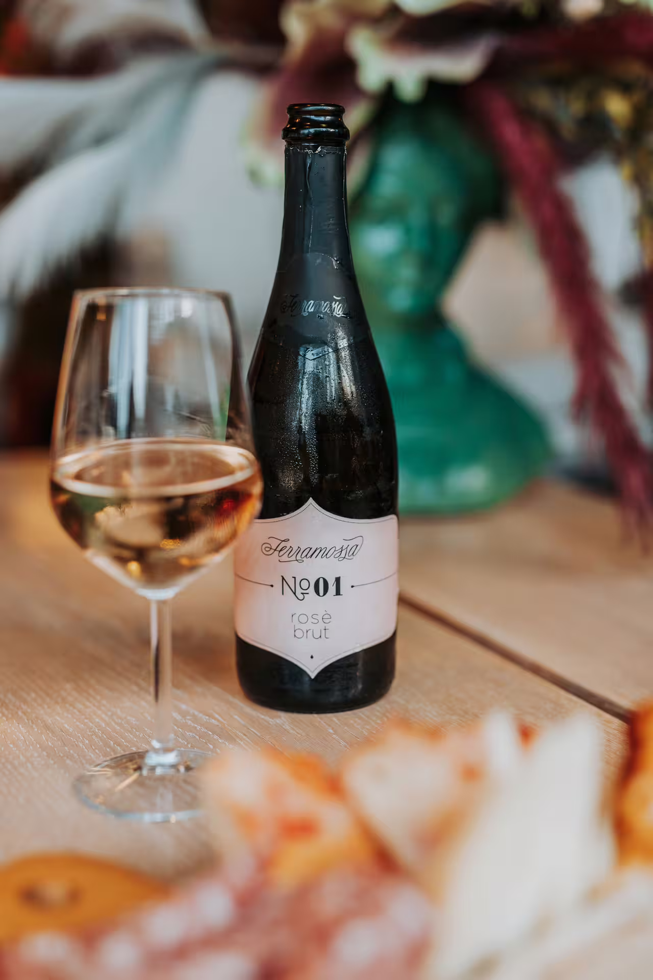 Glass of rosé brut aperitif beside bottle, included with Bagno di Romagna thermal pool 2-hour entry