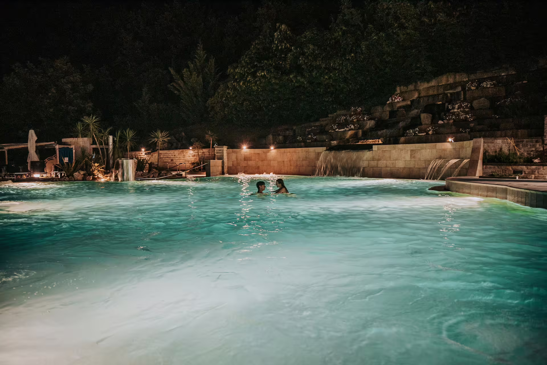Night view of Bagno di Romagna thermal pool with waterfalls, relaxing 2-hour entry after 25-min massage