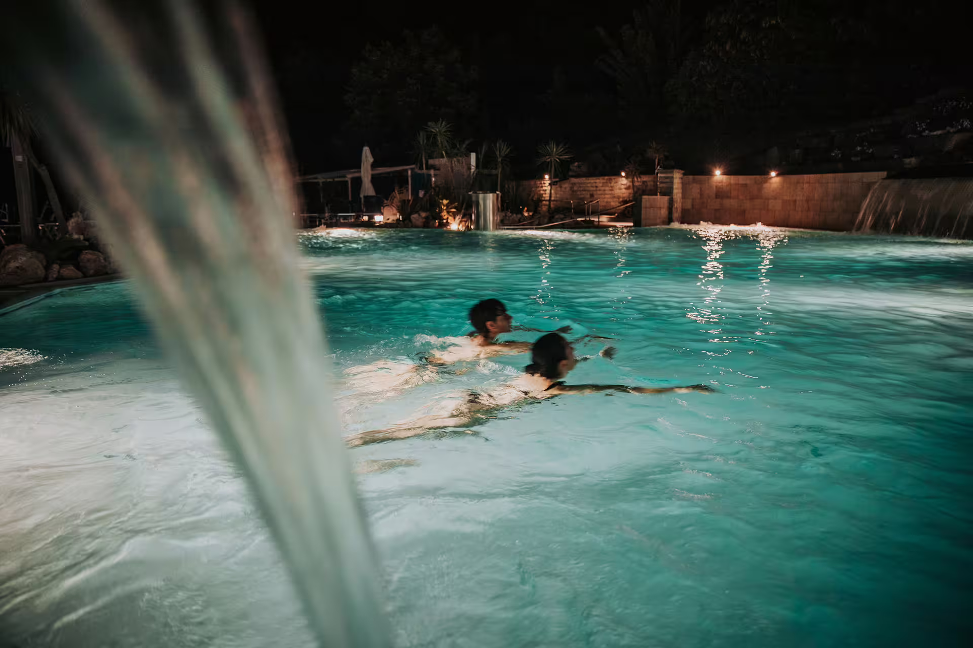 Night swim in Bagno di Romagna thermal pool with waterfall jets, part of massage and aperitif spa package