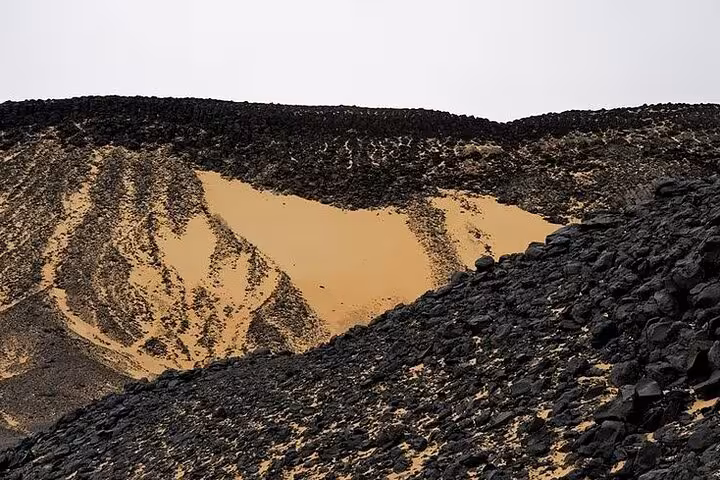 Black Desert volcanic hills and golden dunes in Bahariya Oasis on a 3-day eco camping tour in Egypt