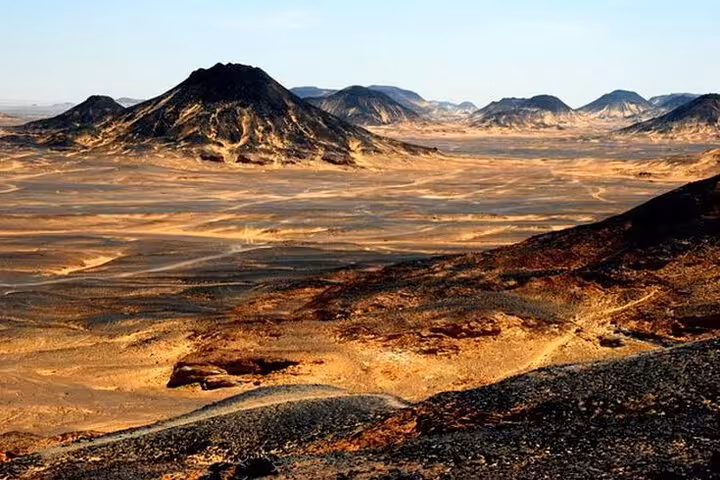 Panoramic view of Egypt’s Black Desert near Bahariya Oasis, rugged volcanic hills on a 3-day eco camp tour