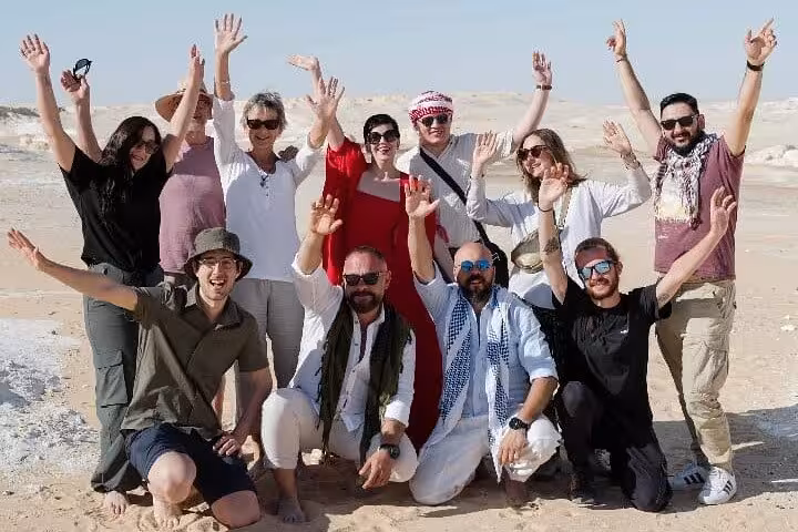 Group of travelers celebrating in Egypt’s White Desert on a 3-day eco Bahariya Oasis camping tour