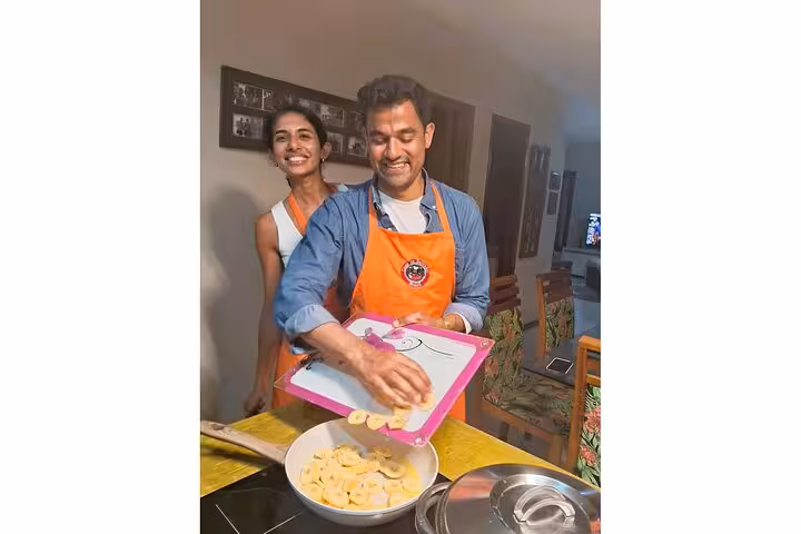 Happy participants slicing bananas during a boozy cooking class in Salvador, perfecting authentic Bahian recipes.