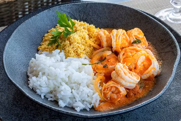 Delicious Bahian shrimp moqueca with rice and farofa served in a traditional dish in Salvador.