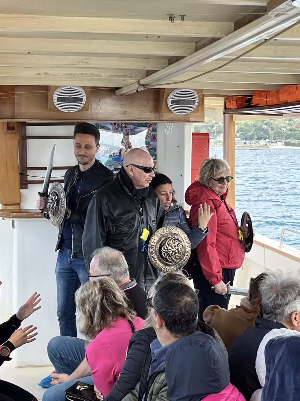 Guests on Baia Sommersa boat tour enjoy live storytelling and Roman-themed props on the Gulf of Naples