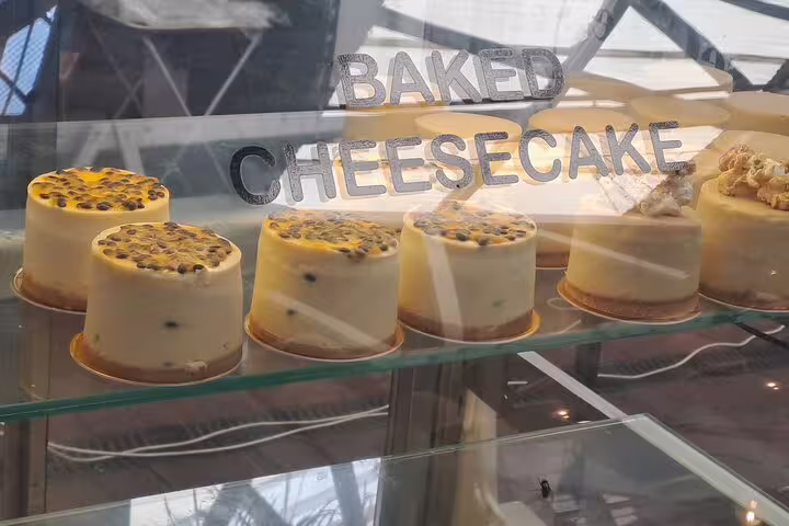 Display of creamy baked cheesecakes with various toppings at a local bakery on a culinary exploration tour.