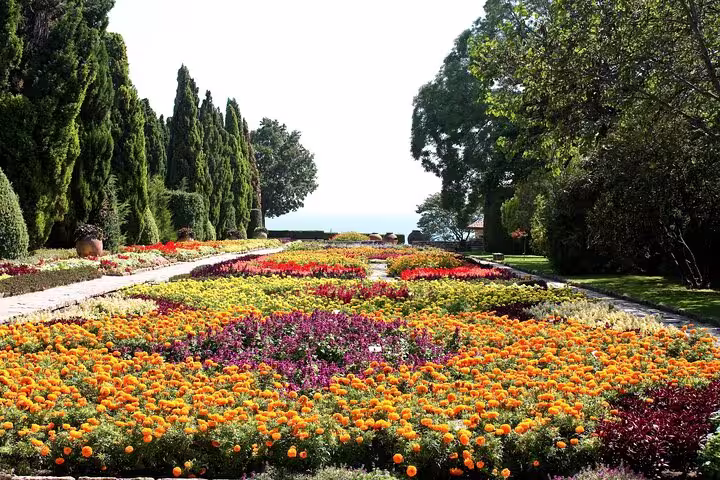 Vibrant floral landscape at Balchik Palace with colorful garden beds and sea view, ideal for a serene walking tour.