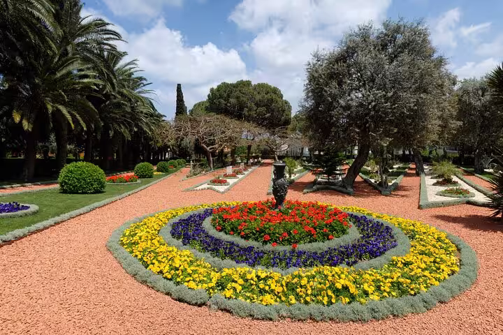 Picturesque garden layout at Balchik Palace featuring colorful flower arrangements and palm trees under a blue sky.