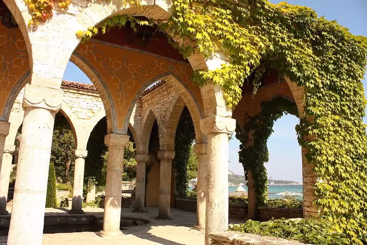 Elegant stone arches with creeping vines at Balchik Palace offering scenic views of the Black Sea.