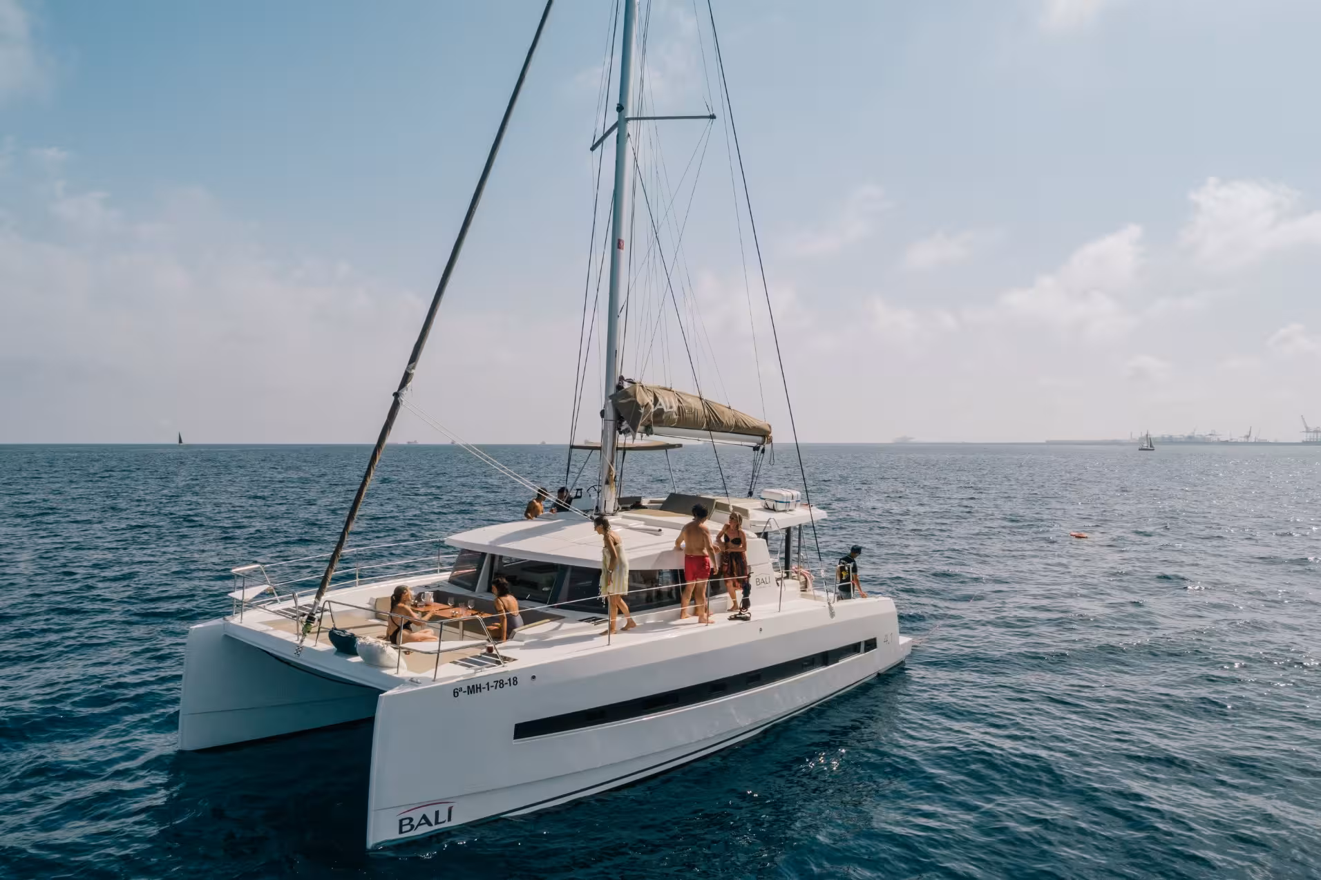 Bali 4.1 private luxury catamaran in Barcelona with guests relaxing on deck during a 2-hour cruise