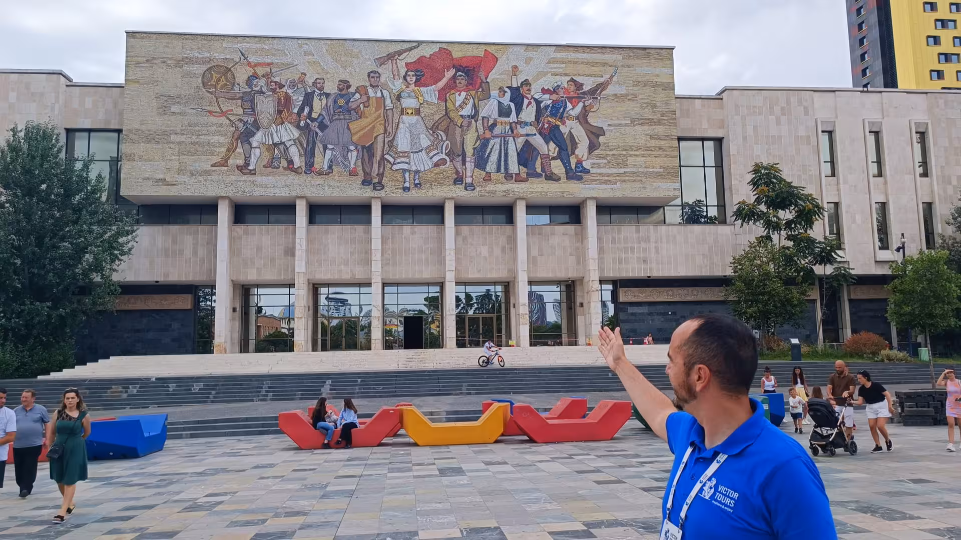 Tourist admires mosaic on the National Museum in Tirana, Albania, during Balkan Express tour.