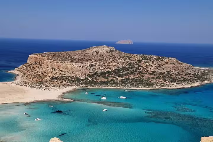 Stunning view of Balos Lagoon's azure waters and rocky island, highlighting a serene spot for a private seafood lunch.