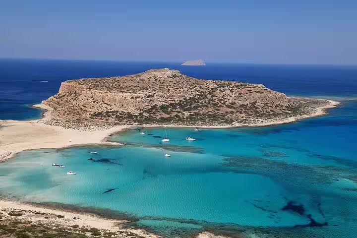 Stunning aerial view of Balos Lagoon with turquoise waters and boats, perfect for a private tour with wine tasting.